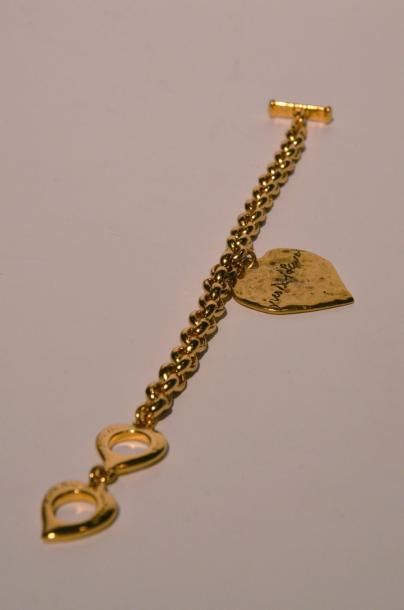 Yves Saint LAURENT Bracelet Love chainette en métal doré retenant un coeur en pampille...