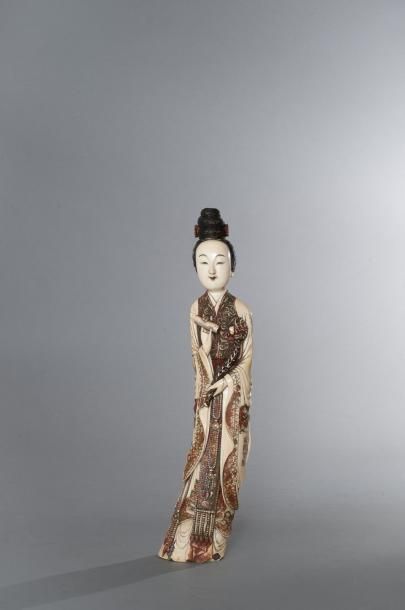 CHINE (NON VENUE) Statuette en ivoire polychrome figurant une femme tenant une fleur...