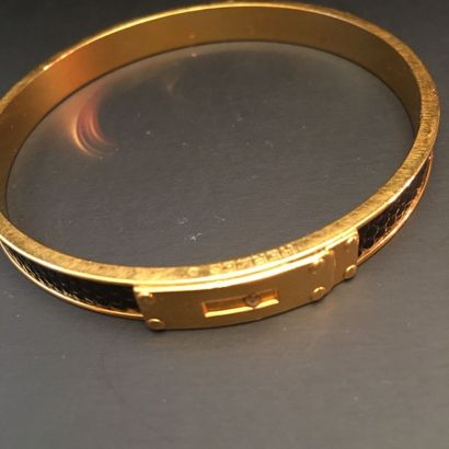 null HERMES Paris. Bracelet jonc en métal doré modèle Sanglon orné d'une bande de...