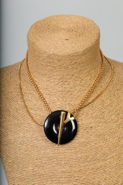 null YVES SAINT LAURENT 

Collier pendentif en métal doré et disque en onyx noir,...