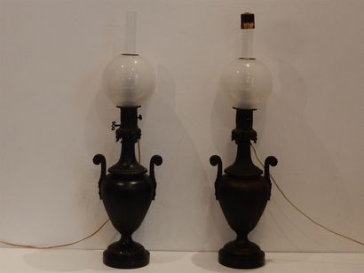 null Une paire de lampes à pétrole en bronze patiné épaulées de deux anses à décor...