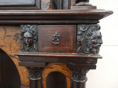 null Un cabinet en bois teinté et ciré ouvrant à deux vantaux sculptés de médaillons...