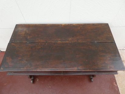 null Un bureau dit "table de changeur", en bois teinté et ciré, posant sur un piétement...
