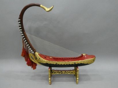 null Une harpe en bois sculpté et ajouré, laqué or et rouge, rehaussée de petits...
