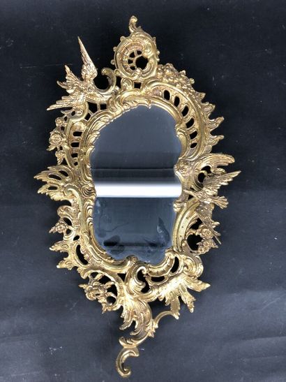 null Un miroir ovale en bronze doré à décor d'un oiseau en plein vol, style rocaille,...