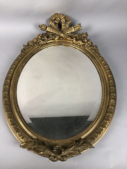 null Un miroir ovale en bois et stuc doré surmonté d'un ruban noué, style Louis XVI,...