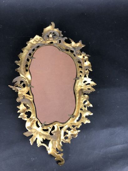 null Un miroir ovale en bronze doré à décor d'un oiseau en plein vol, style rocaille,...