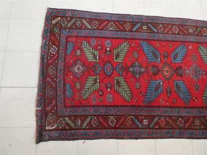 null Un tapis galerie en laine à décor stylisé sur fond rouge, 103 x 482 cm