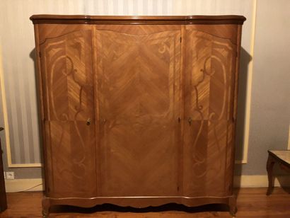null SUR DESIGNATION : Une armoire en bois de placage ouvrant à trois vantaux, style...