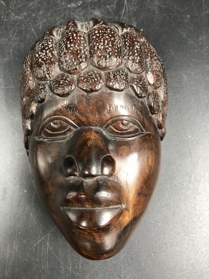 null Un motif d'applique en ébène sculpté figurant un visage d'homme africain, vers...