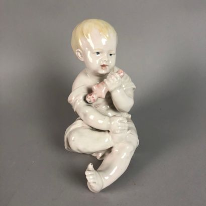 null Un bébé assis jouant à la poupée en céramique, marque CA sous la base, hauteur...