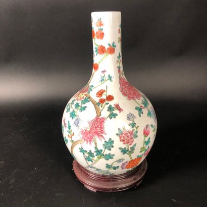 null Un vase bouteille en porcelaine à décor floral polychrome socle bois, Chine...