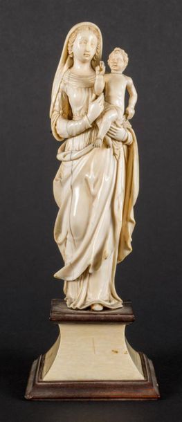 null Vierge à l'Enfant en ivoire sculptée en ronde-bosse. Debout, la Vierge porte...