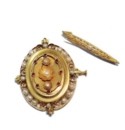 null Oval openwork gold brooch, cultured pearls and red stones.

A gold brooch with...