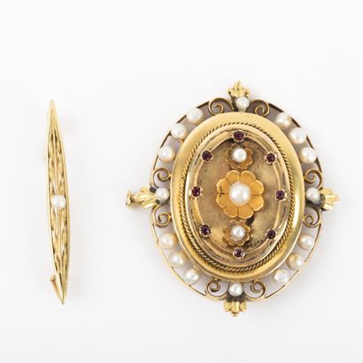 null Oval openwork gold brooch, cultured pearls and red stones.

A gold brooch with...
