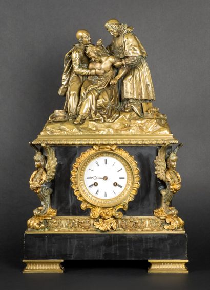 Black marble clock topped by a religious...