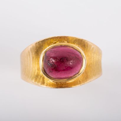* 18K gold ring with a central ruby in cabochon...