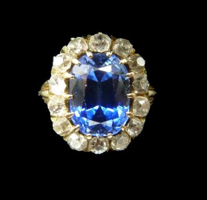 null Bague marguerite en or serti d'une pierre bleue, entourage de diamants taille...