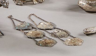 null A series of 6 silver bottle necklaces, the plates decorated with embossed vine...