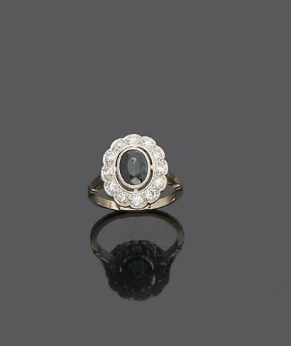 null 18 k (750 thousandths) white gold ring set with an oval sapphire surrounded...