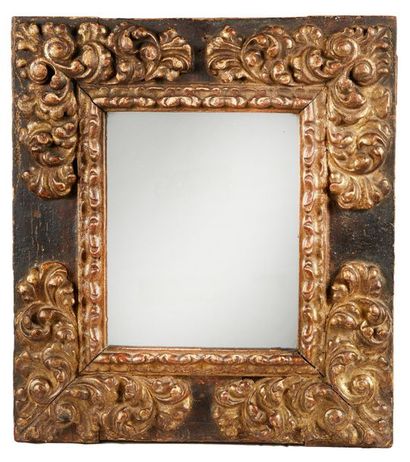 null Cadre formant miroir en bois noirci et doré sculpté d'écoinçons à rinceaux fleuris...