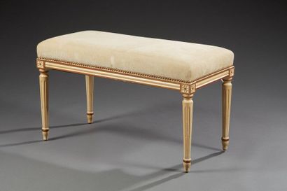 null Un banc de style Louis XVI en bois laqué rechampi doré, garni d'une toile ecrue...