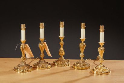 null Ensemble de cinq flambeaux de syle Louis XV en métal doré (l'un présentant une...