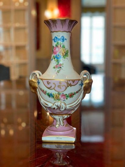 null Vase en porcelaine à décor polychrome et doré de trophées fleuris, anses têtes...