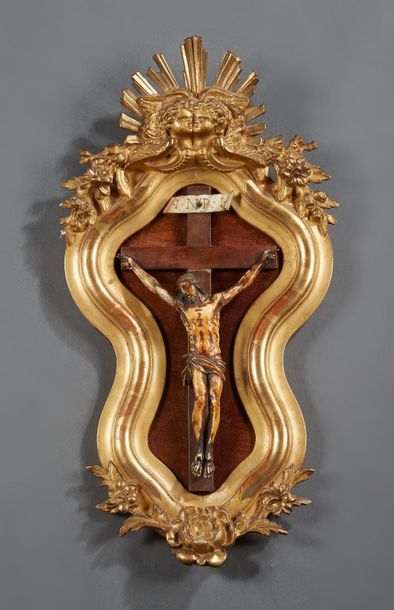 null Christ en ivoire sculpté et patiné dans un cadre de forme violonée en stuc doré...