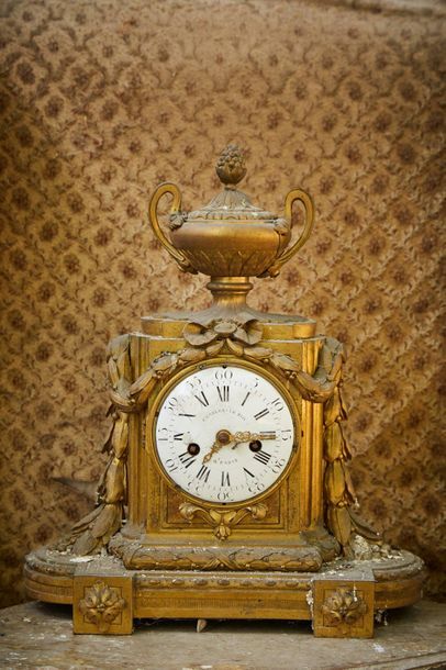 null Gilded bronze clock with a covered pot with a socket featuring a fruit and a...