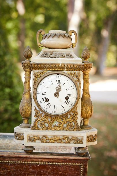 null White marble clock decorated with gilded bronze baluster columns, floral motifs...