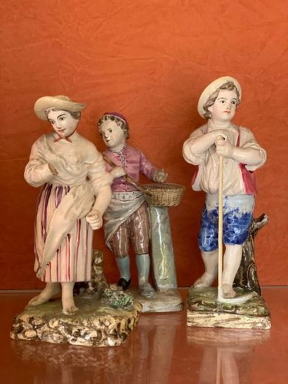 null Trois statuettes en faïence fine à décor polychrome représentant des enfants...