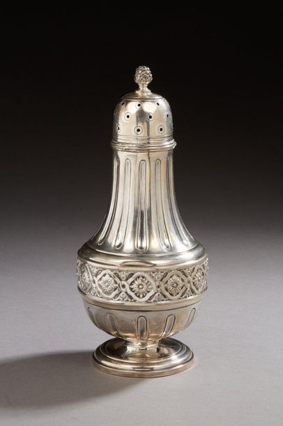 null A baluster-shaped silver sprinkler, the shaft with a vegetal decoration surmounting...