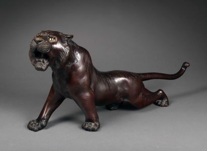 null A bronze sculpture with a reddish brown patina representing a roaring tiger,...