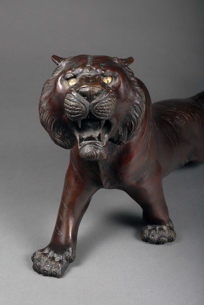 null A bronze sculpture with a reddish brown patina representing a roaring tiger,...