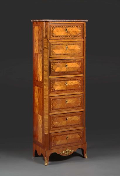 null Veneered weekly chest of drawers opening to seven drawers decorated with a marquetry...