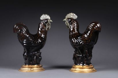 null Pair of roosters in brown and green glazed earthenware, they stand on a circular...