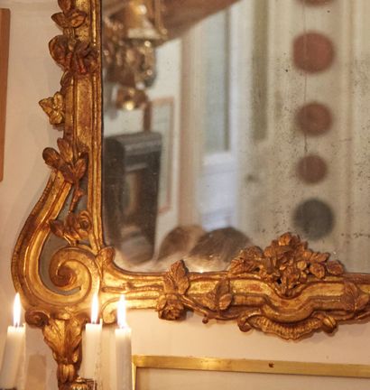 null 
Miroir en bois sculpté et doré à décor de parecloses sur les enroulements latéraux,...