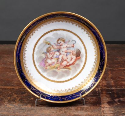 null Plat creux à gâteaux en porcelaine de Sèvres à décor peint de trois anges représentant...