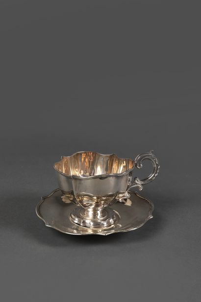 null Large silver cup and saucer of poly-lobed form, the edge curved, highlighted...