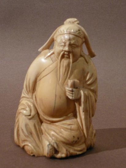 null Sculpture en ivoire sculpté représentant un personnage assis. Travail chinois....