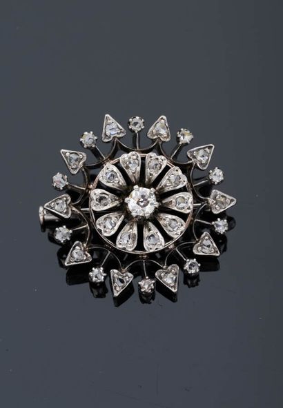 null Silver and metal flower brooch set with diamonds, one of which is more important...