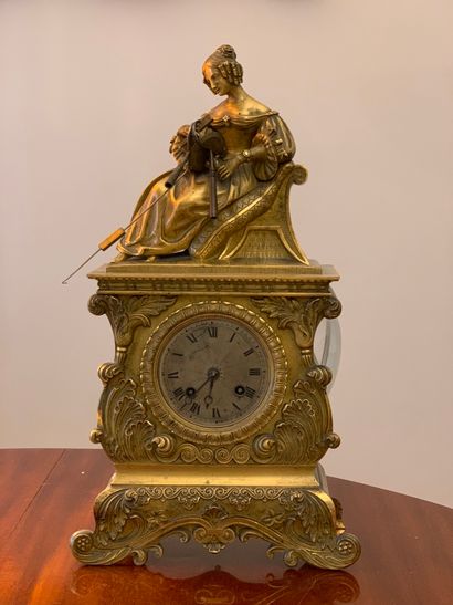 null Gilt bronze clock, the body surmounted by a sculpture representing a lady of...