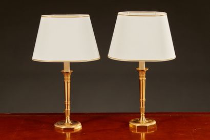 null Pair of Empire style torch lamps in brushed brass. Oval lampshade in white fabric.
55,5...