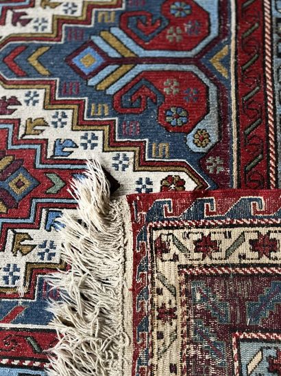 null Caucasus carpet with blue, green and red background with four central motifs...