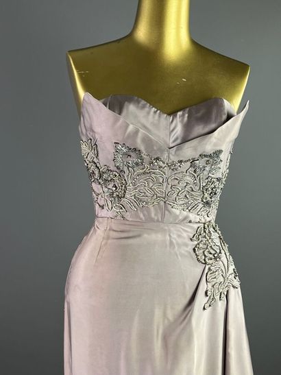 null GERMAINE LECOMTE Robe du soir en satin parme et broderie strassée Vers 1950

Le...