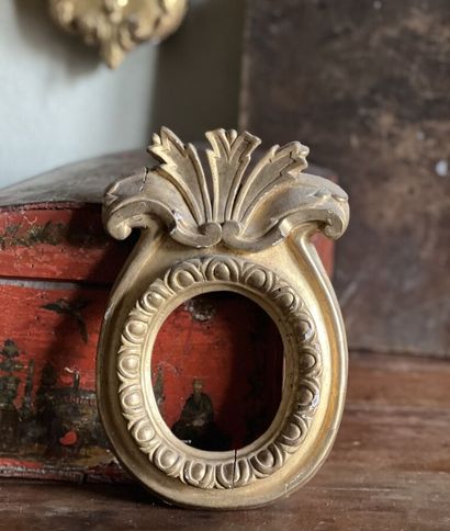 Carved and gilded wood frame with an oval...