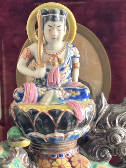 null Polychrome porcelain statue representing Buddha holding a sword, seated on a...