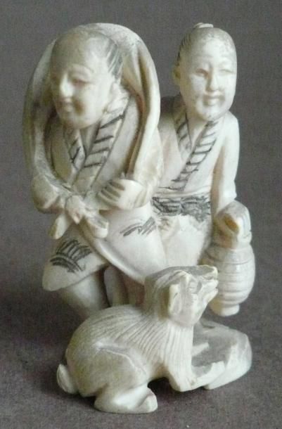 null Netsuke en ivoire représentant deux hommes et un chien. Japon, XXe siècle. H:...