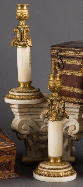 null PAIRE DE BOUGEOIRS en bronze ciselé et doré et marbre blanc, à décor de feuillage...